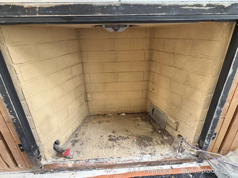 Empty firebox prepped for gas log installation with gas stub and shutoff valve visible